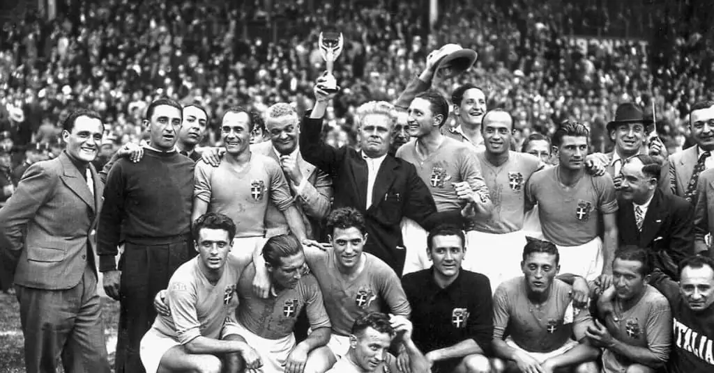 vittorio pozzo holding the world cup trophy aloft with his team