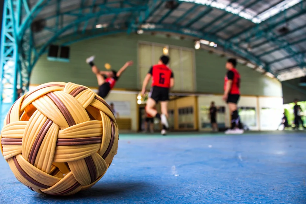 Close up of sepak takraw ball and game in background