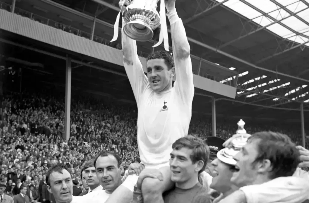 Dave Mackay being carried around Wembley by his teammates with the fa cup trophy