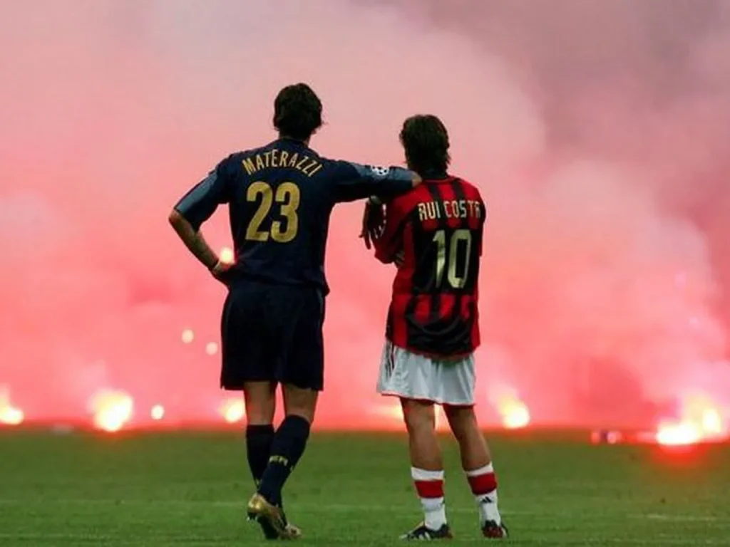 players watch on as fans throw flares onto the soccer field