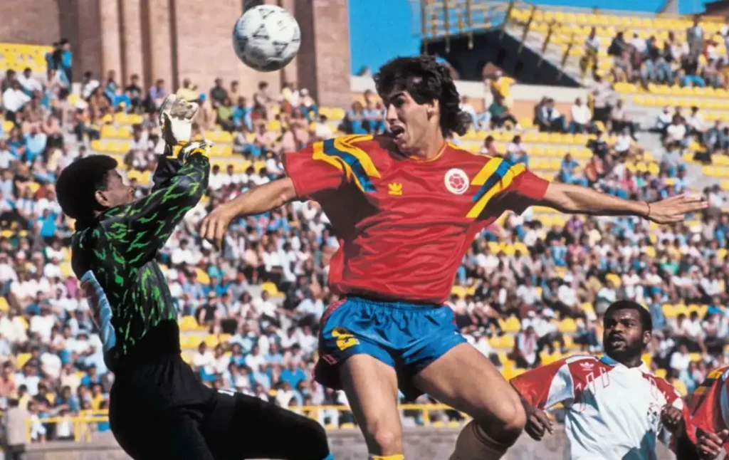 andres escobar challenging the goalkeeper in a aerial duel