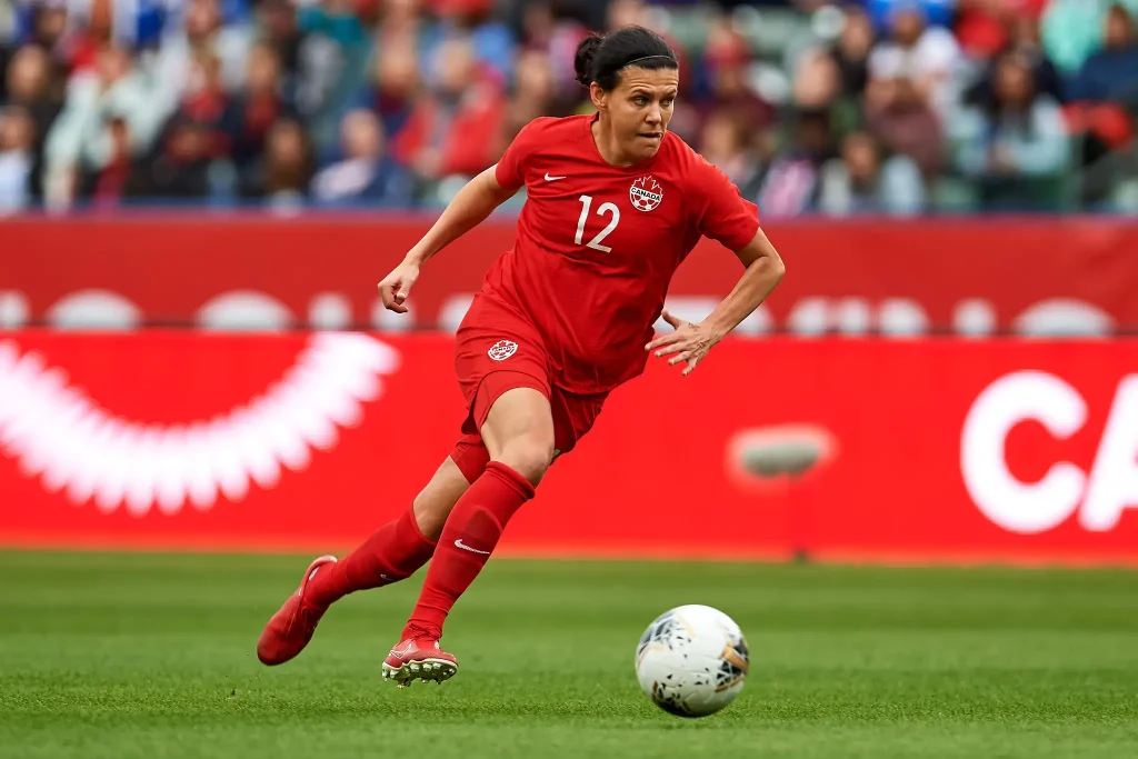 christine sinclair running towards the soccer goal with ball