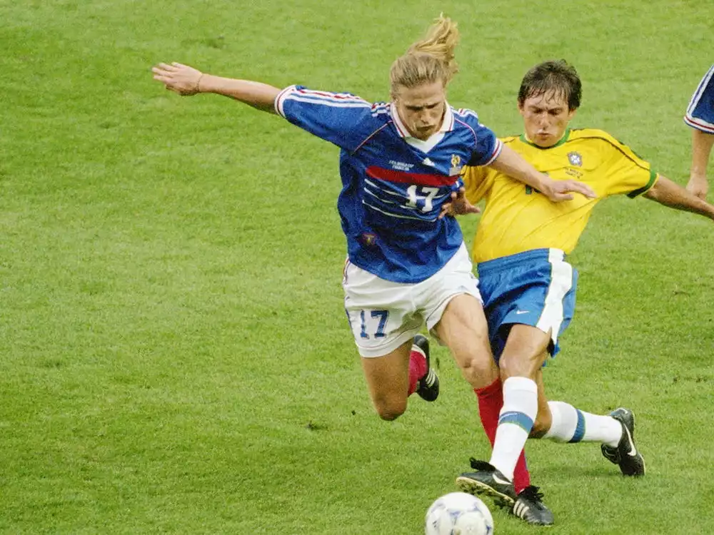 emmanuel petit taking the soccer ball away from brazilian attacker