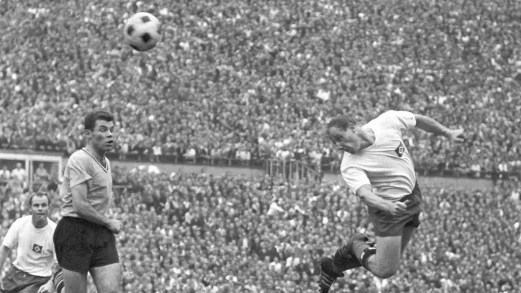 uwe seeler diving backwards for a header towards the goals