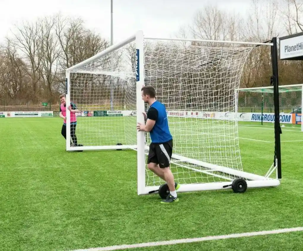 two people moving football goal posts