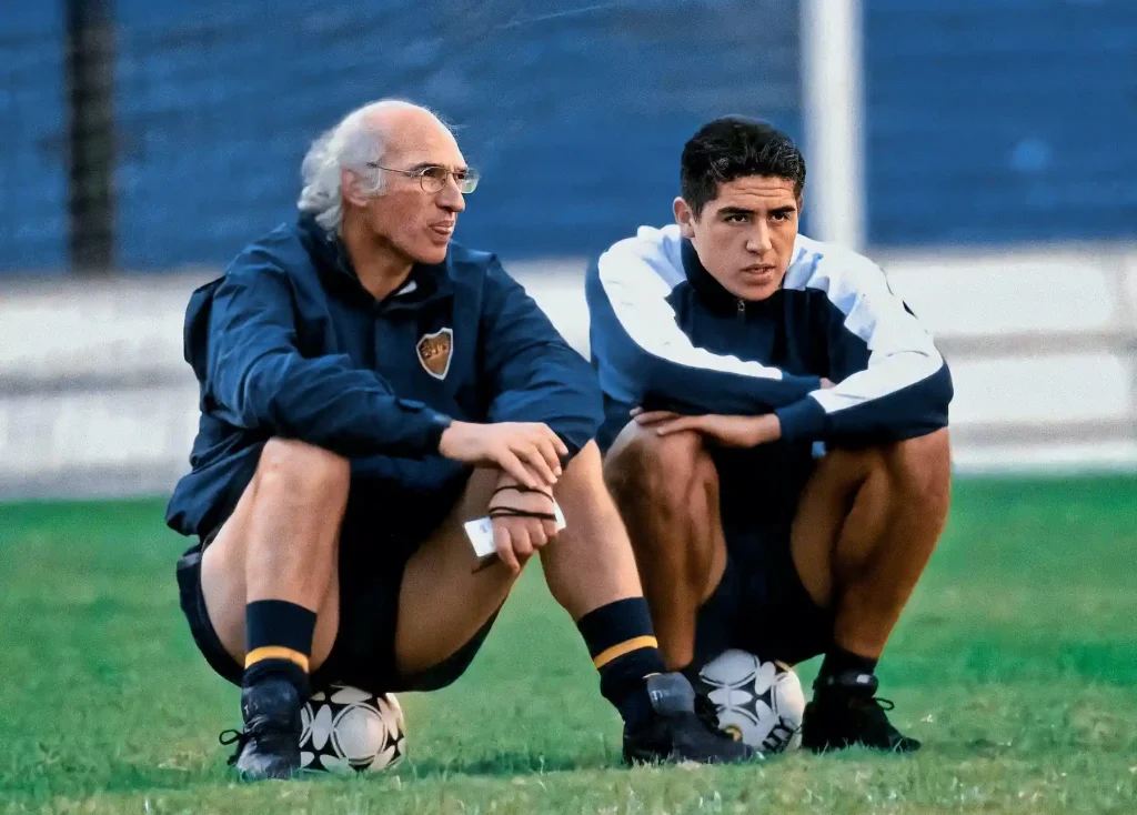 Carlos Bianchi sitting on a football speaking to a player