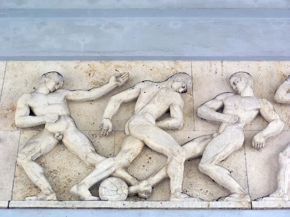marble artwork of men playing football from ancient Greece