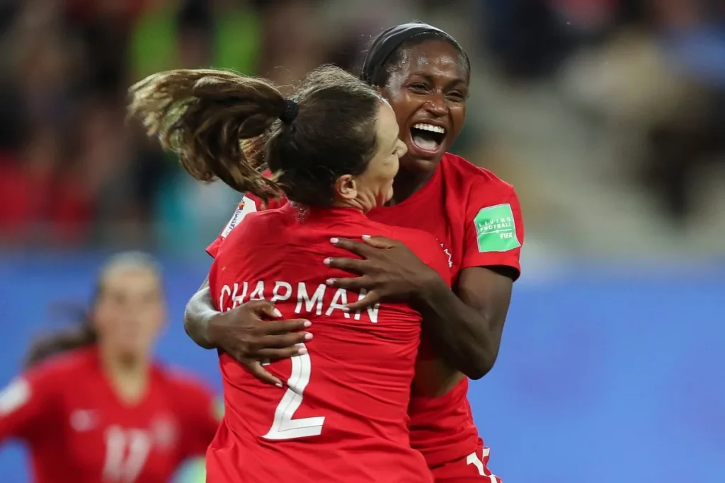 canada women soccer players hug and congratulate each other