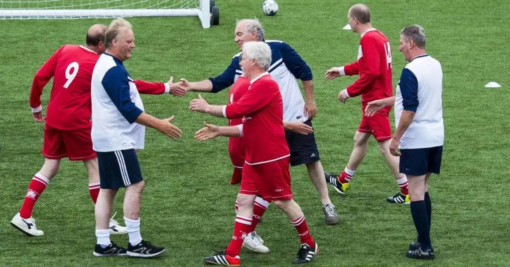 older football players shaking hands
