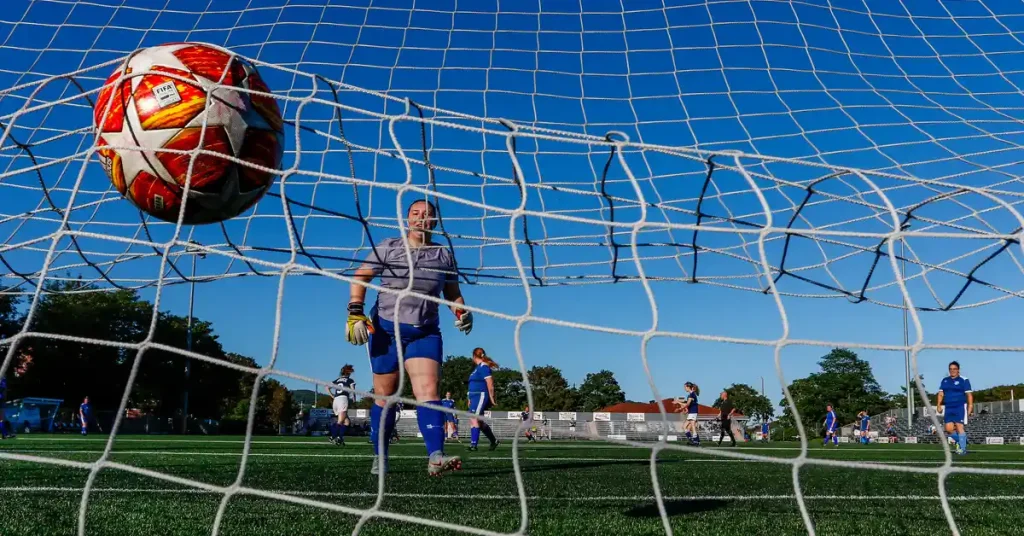 Goalkeeper getting ball out of soccer net