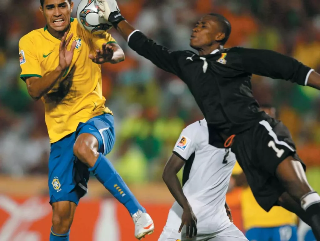 goalkeeper Daniel Agyei challenging the ball with brazilian attacher