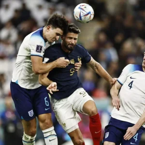 Olivier Giroud and Harry Kane jumping for the soccer ball